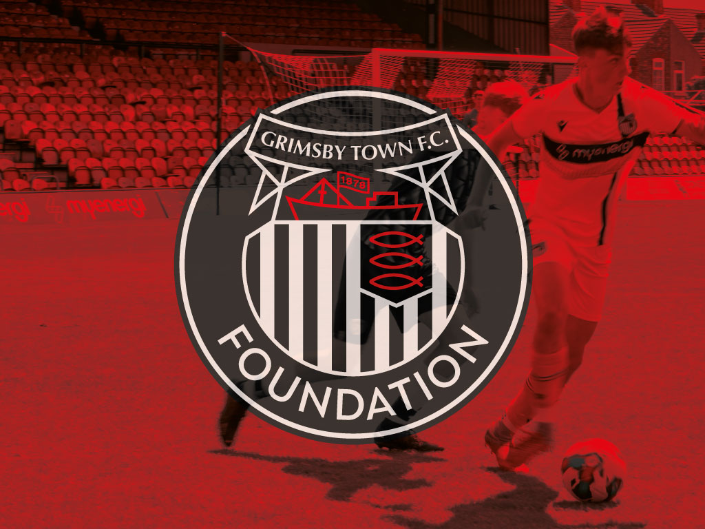Grimsby Town Foundation placeholder image. Includes GTFC badge, the wording "Foundation" and a youth player playing football covered in a red overlay.