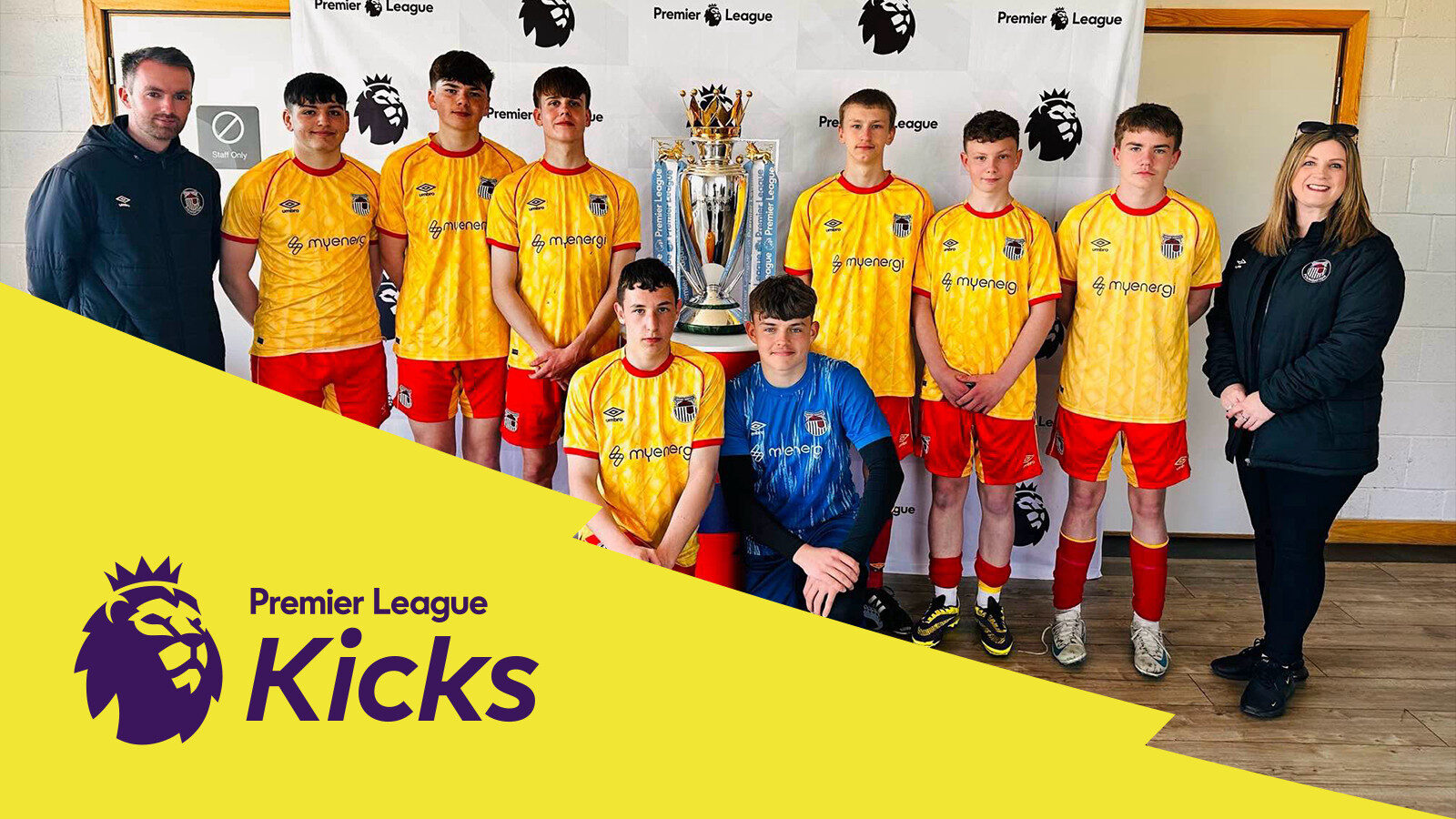 A youth soccer team in yellow and red uniforms poses with a trophy, flanked by two adults. A "Premier League Kicks" banner is displayed in the foreground.